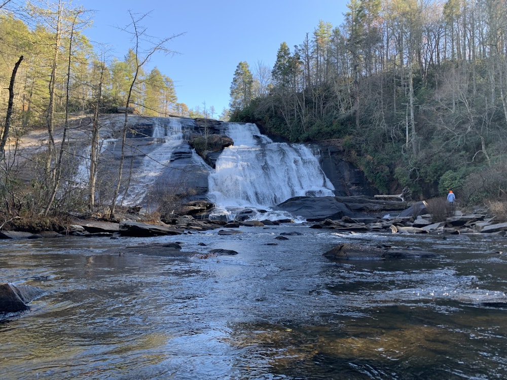 a man standing in front of a waterfall