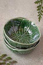 a stack of green bowls sitting on top of a floor