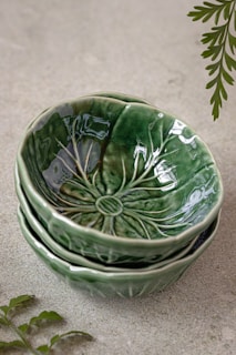a stack of green bowls sitting on top of a floor
