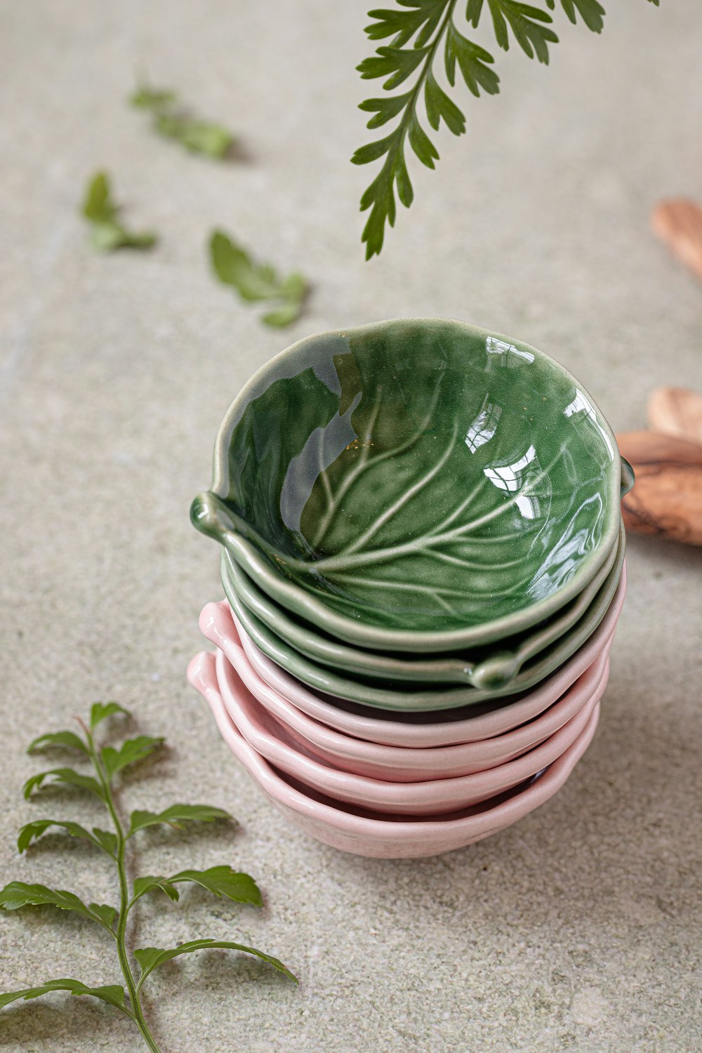 a stack of green and pink dishes sitting on top of each other
