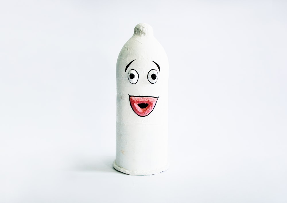a white bottle with a face drawn on it