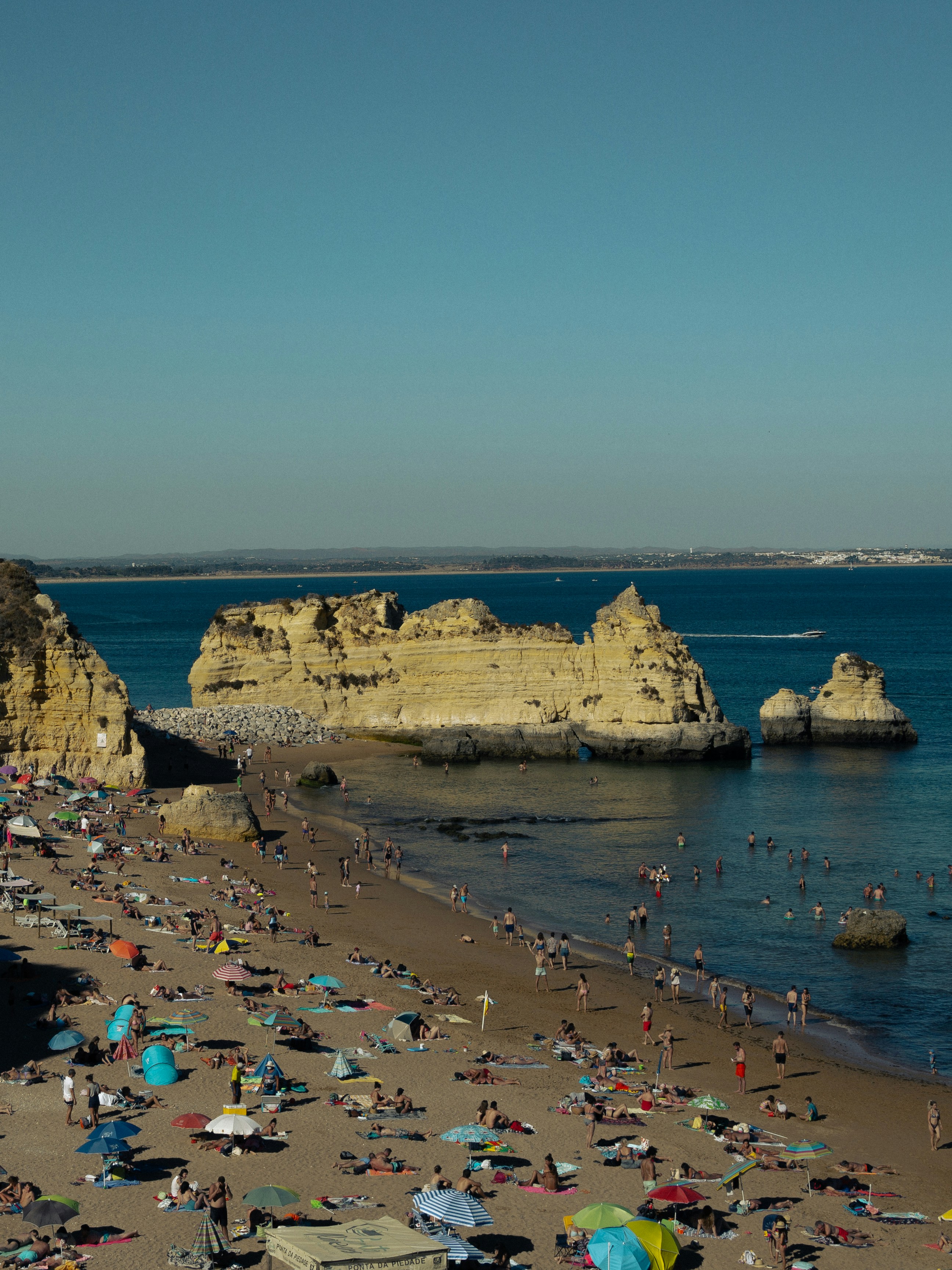 a crowded beach with many people and umbrellas