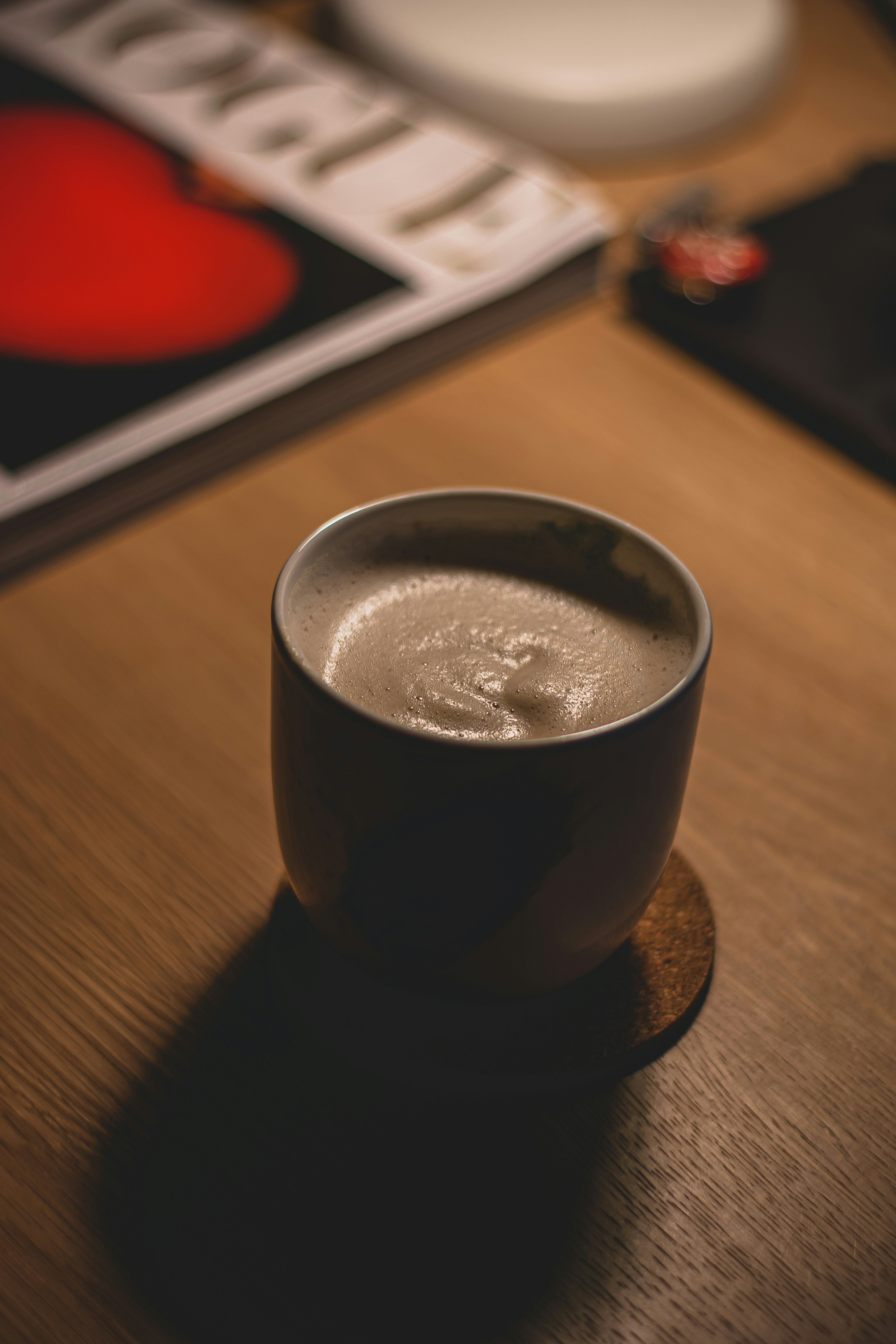 a cup of coffee sitting on top of a wooden table