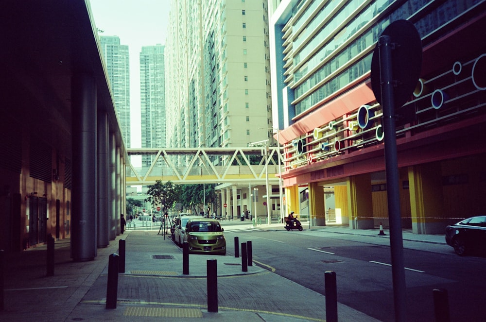 a car parked on the side of a road next to tall buildings