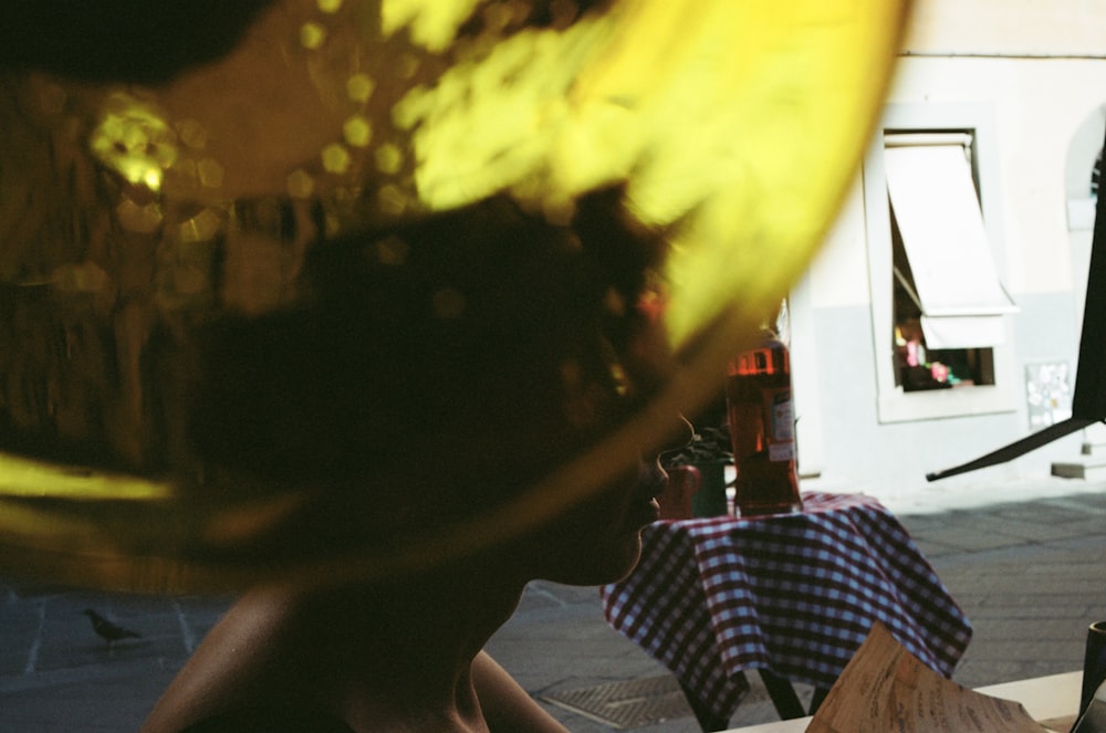 a person sitting at a table with a bottle of beer