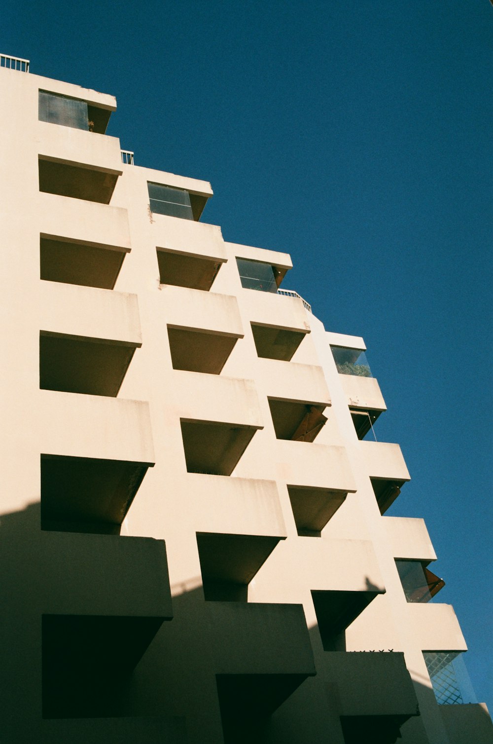 a tall white building with balconies on the side