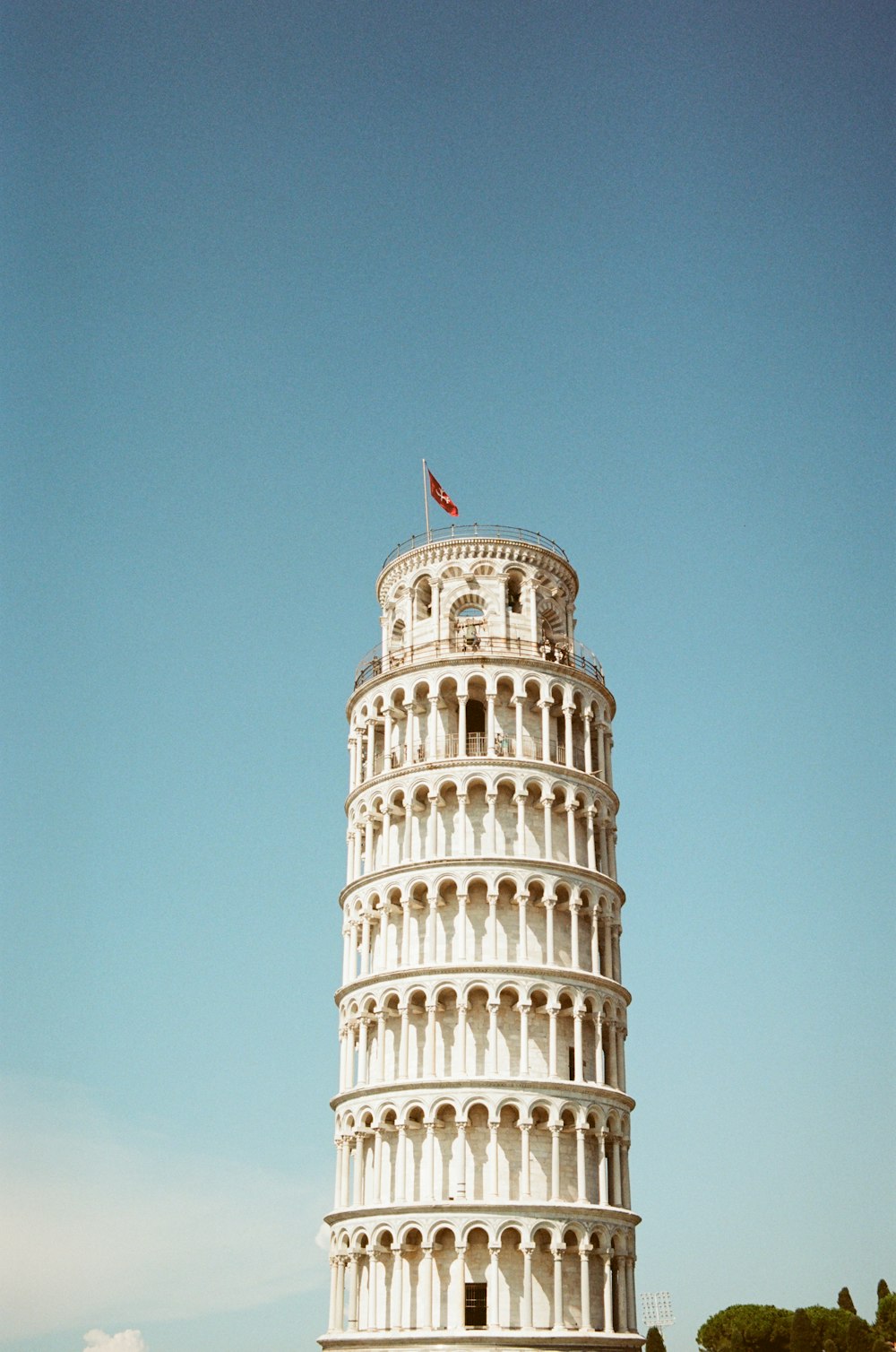 a tall white tower with a flag on top of it