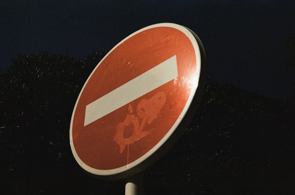 a close up of a street sign with trees in the background