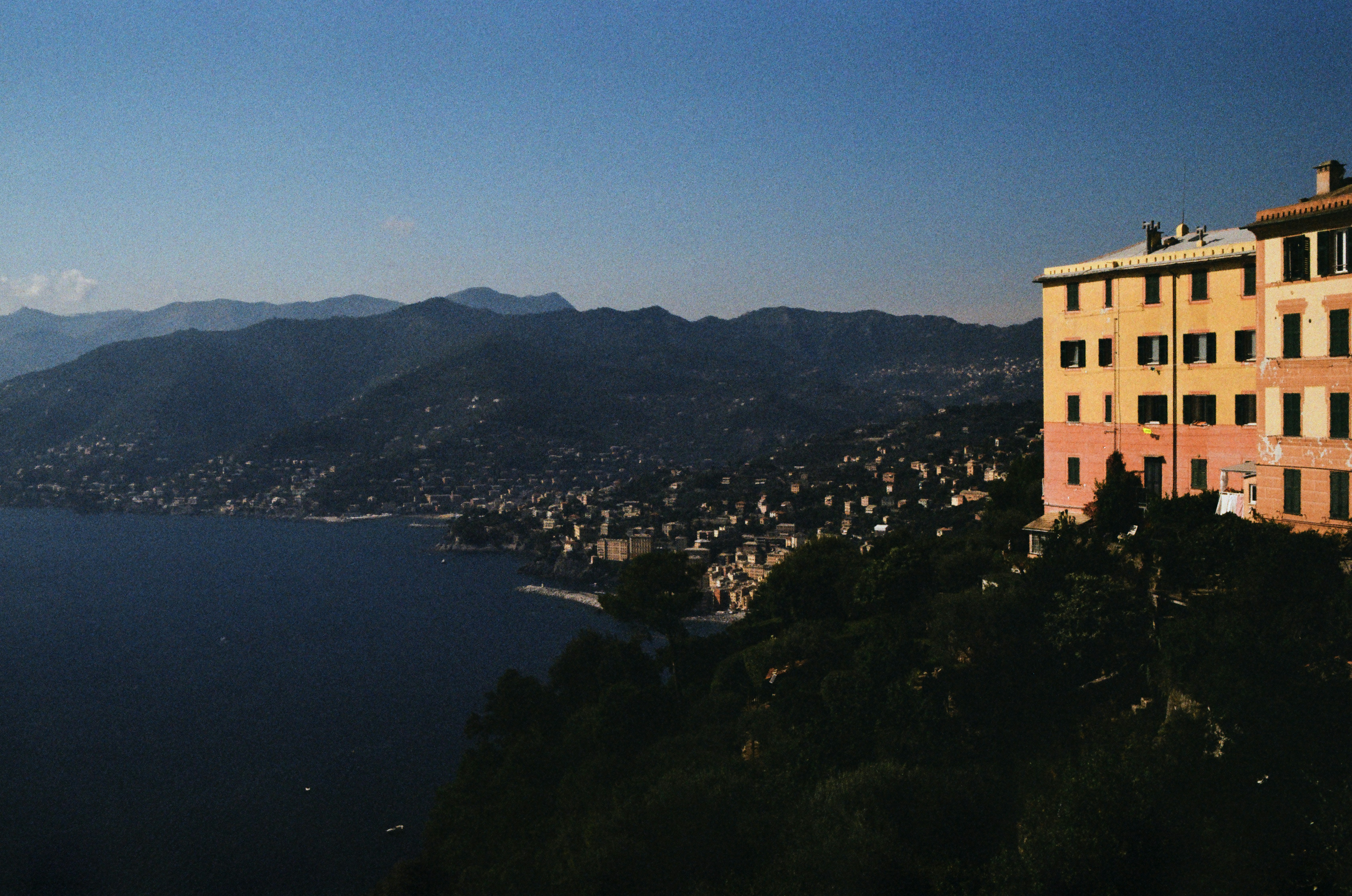 a building on a hill overlooking a body of water