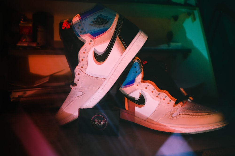 a pair of white and black sneakers on top of a table