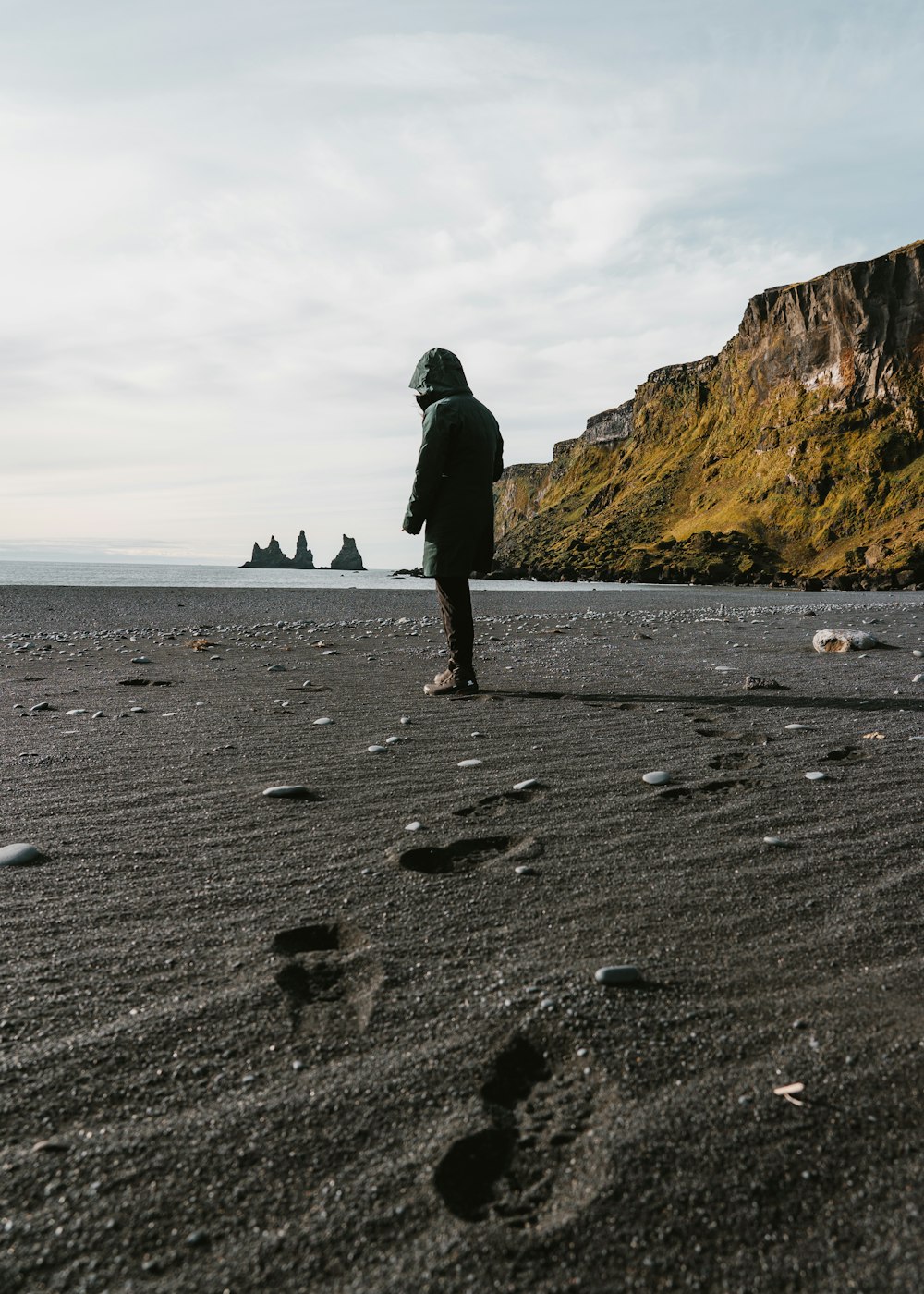 a person standing on a beach next to the ocean