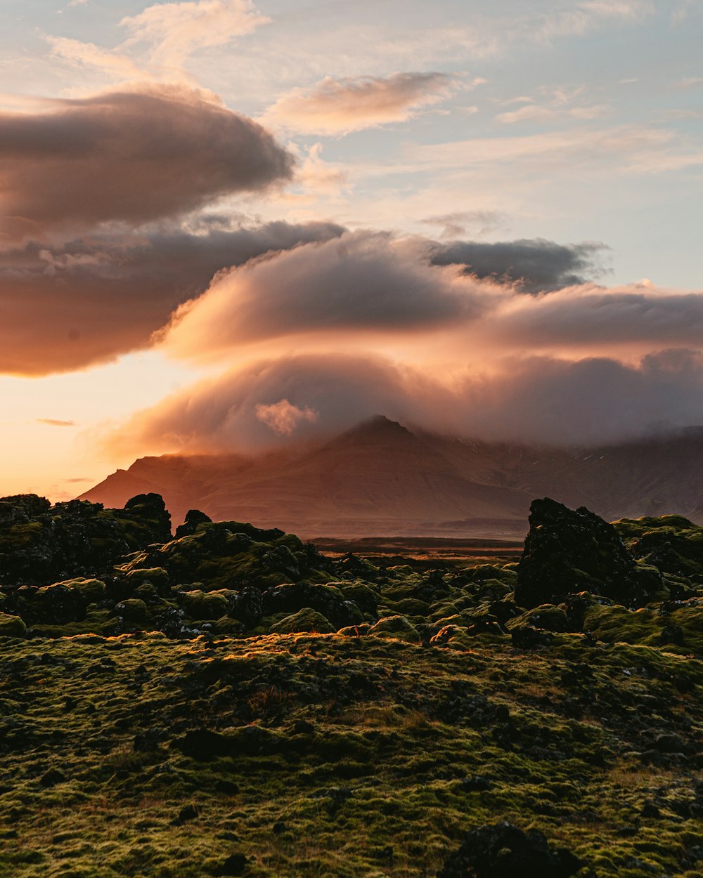 the sun is setting over a mountain range