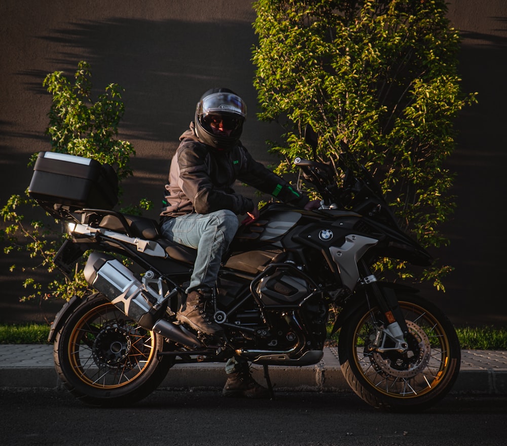 Un hombre sentado en una motocicleta con un casco puesto