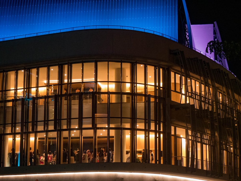 a group of people standing outside of a building at night