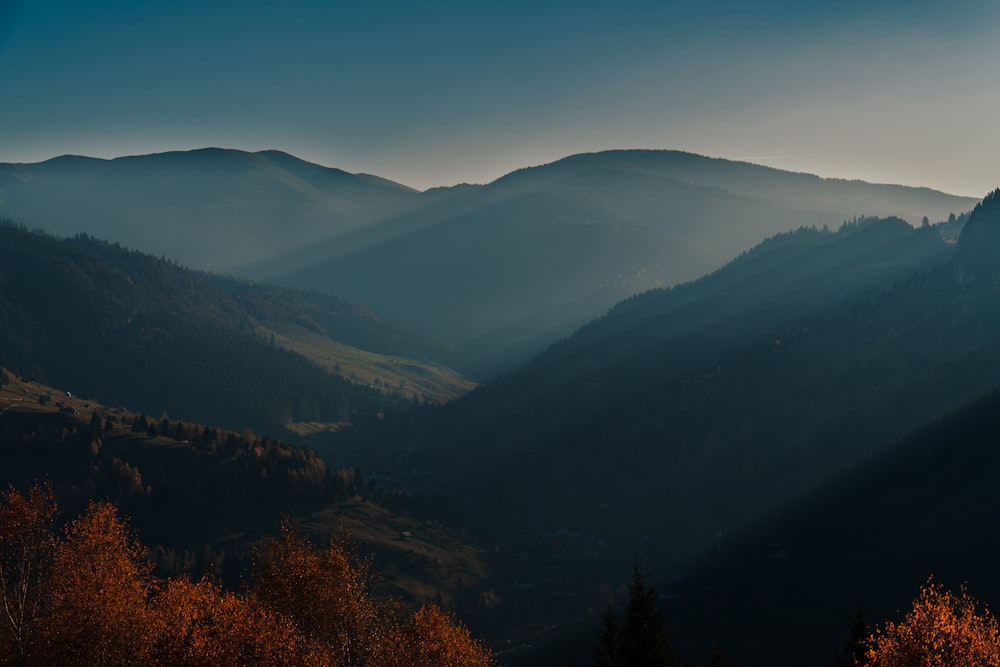 a view of a mountain range with trees in the foreground