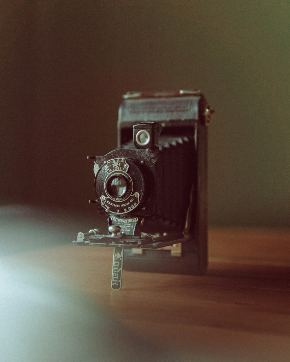 an old camera sitting on top of a wooden table