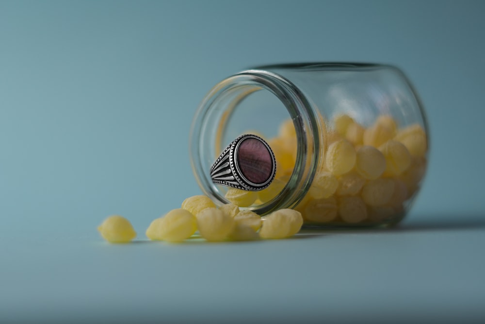 a glass jar filled with yellow candies on top of a table