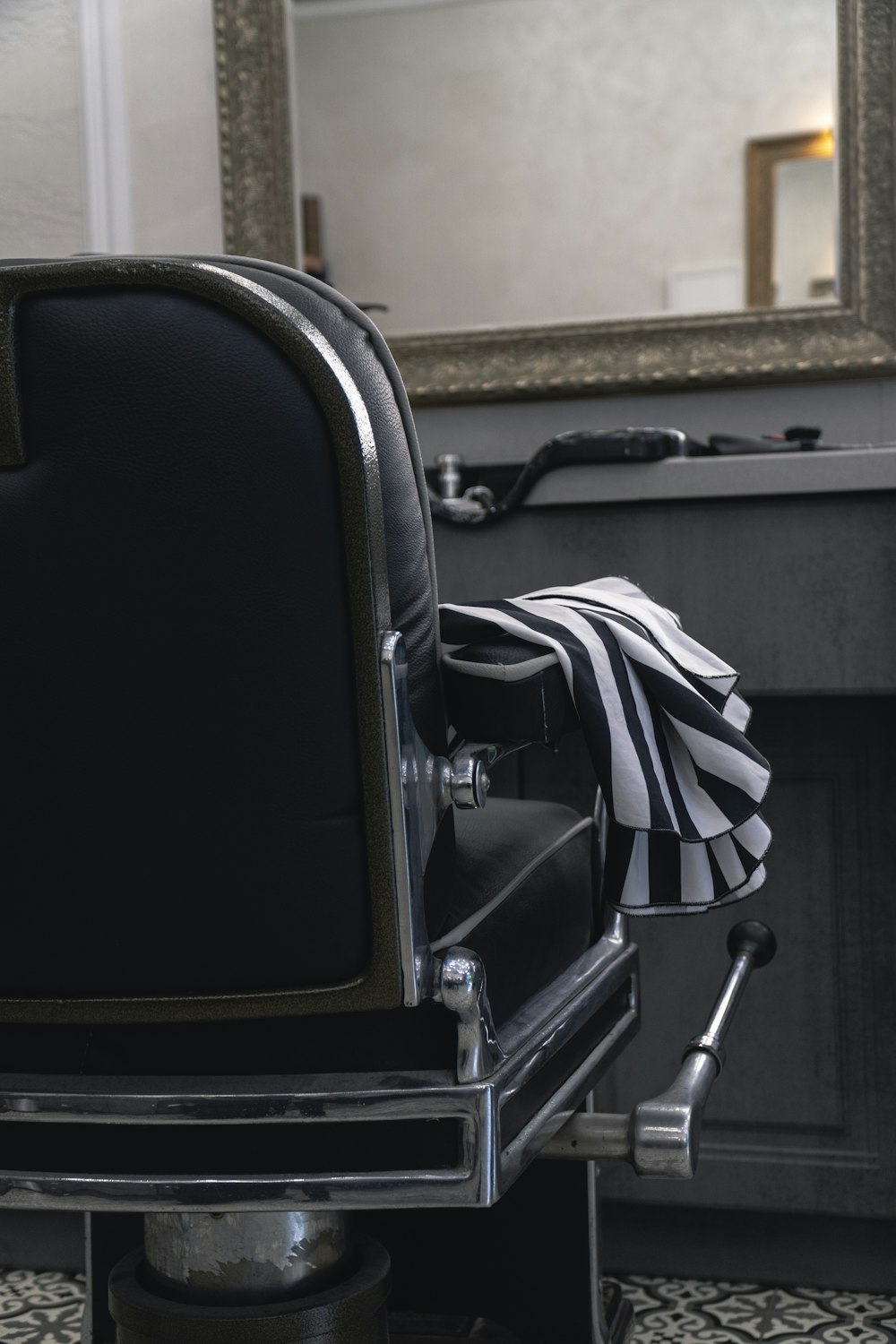 a black and white striped chair in front of a mirror