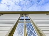 a tall building with two windows and a sky background