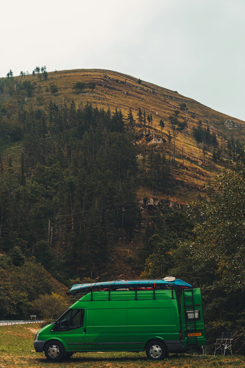 a green van parked in front of a mountain