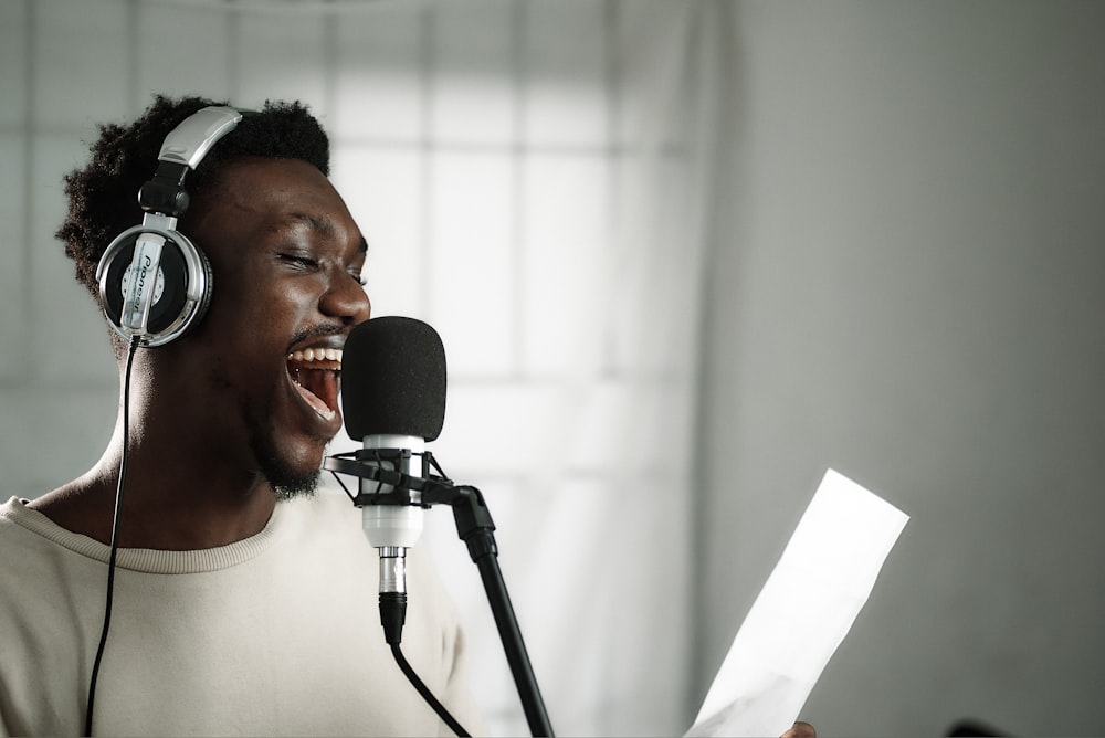 Ein Mann mit Kopfhörern singt in ein Mikrofon