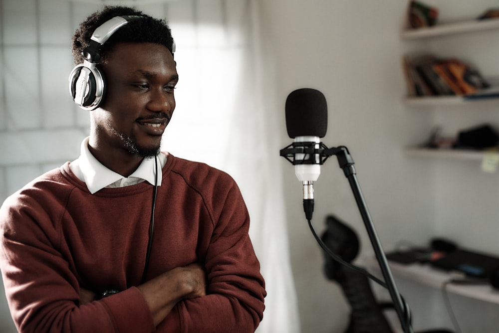 a man wearing headphones standing in front of a microphone