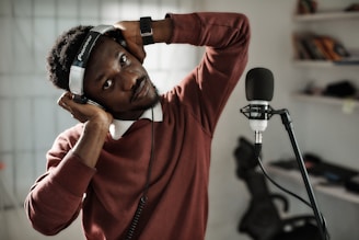 a man wearing headphones while standing in front of a microphone