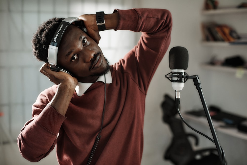 Un hombre con auriculares mientras está parado frente a un micrófono