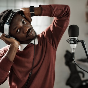 a man wearing headphones while standing in front of a microphone