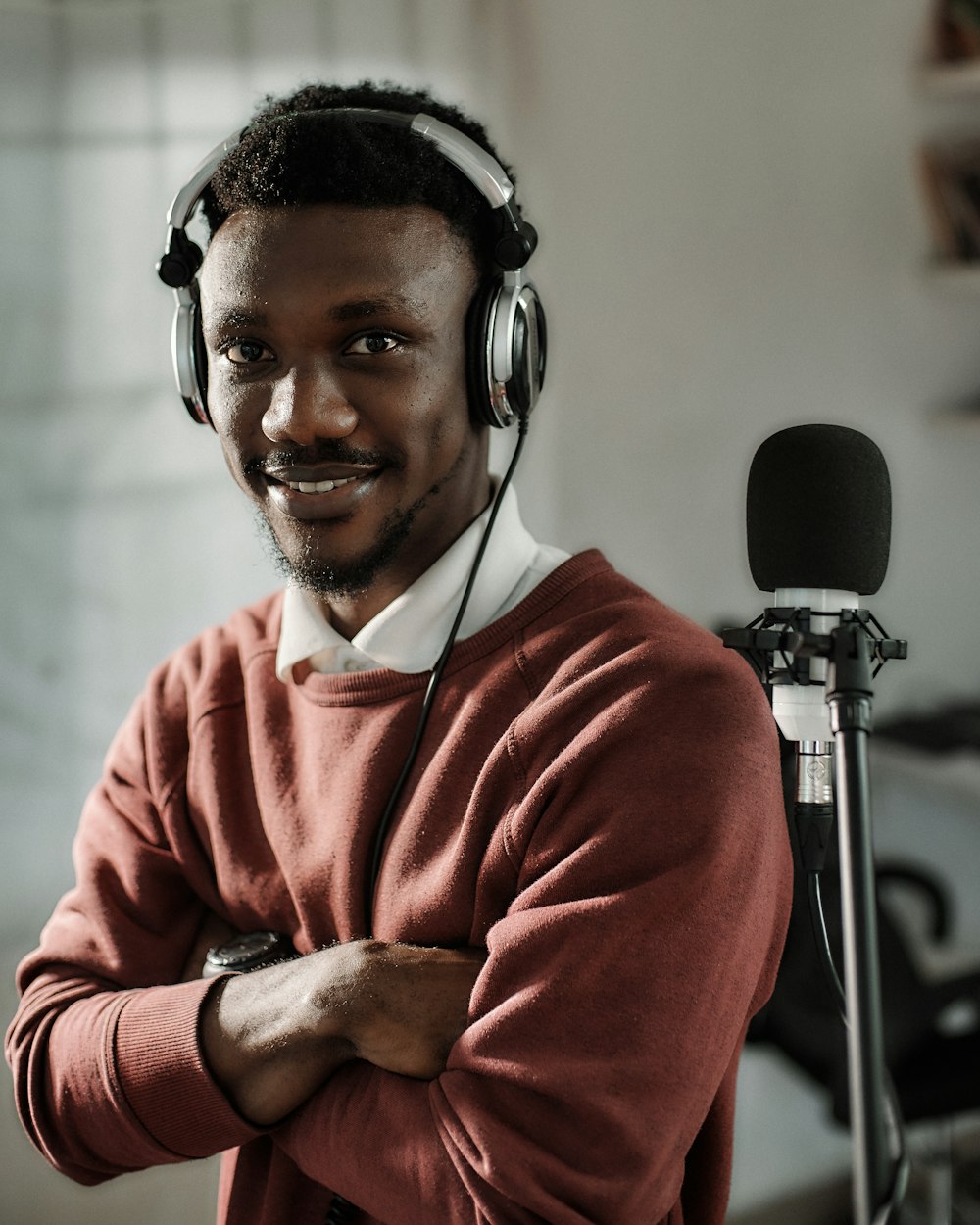 a man wearing headphones standing in front of a microphone