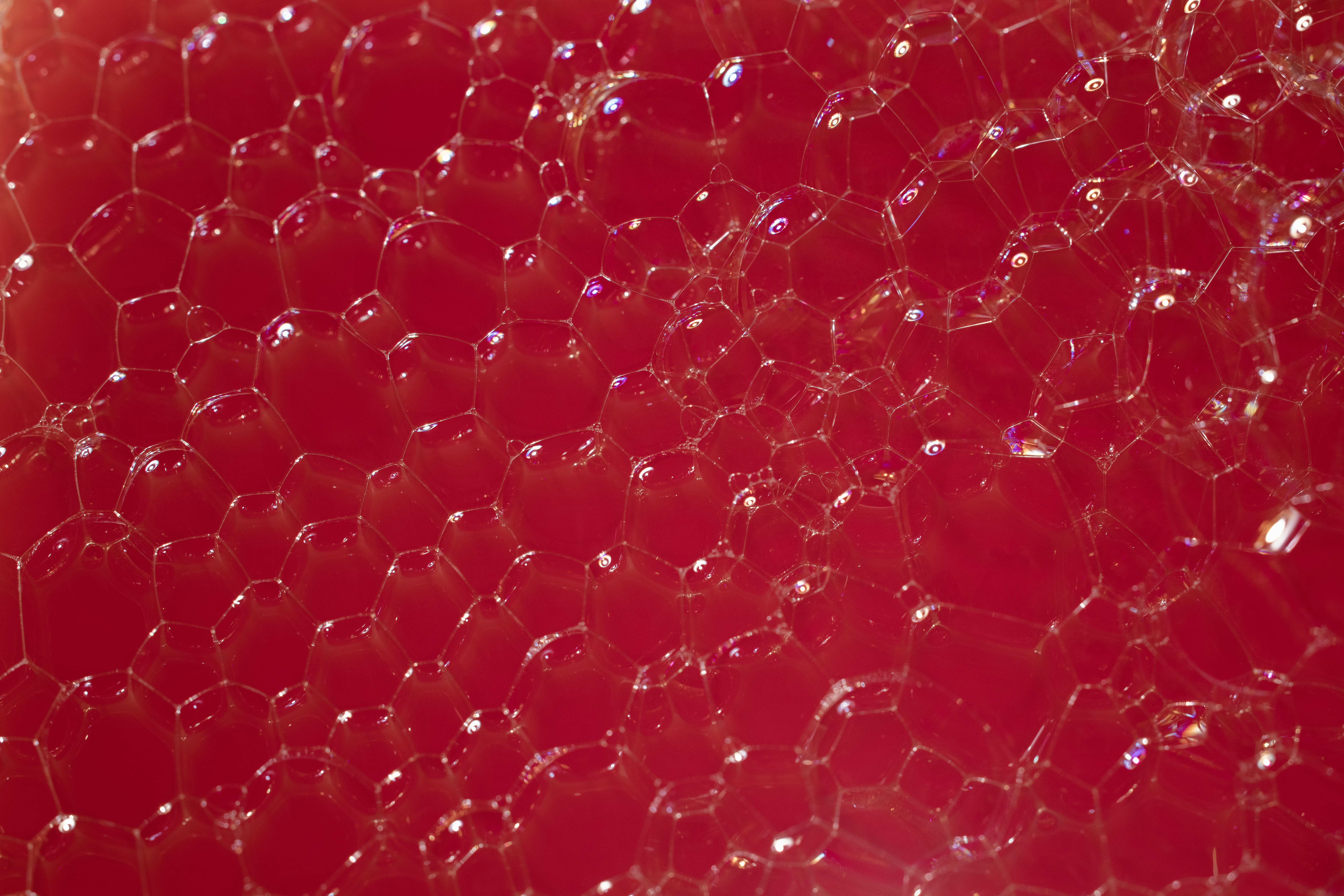 a close up of a red surface with bubbles
