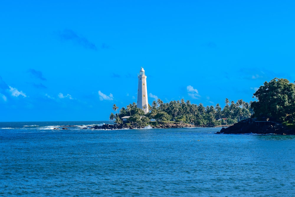 a lighthouse on a small island in the middle of the ocean