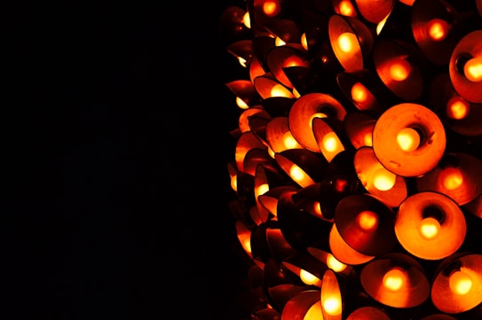 A collection of circular, orange-hued lights arranged in a dense, overlapping pattern against a dark background. The lights have a soft, warm glow, creating an inviting ambiance.