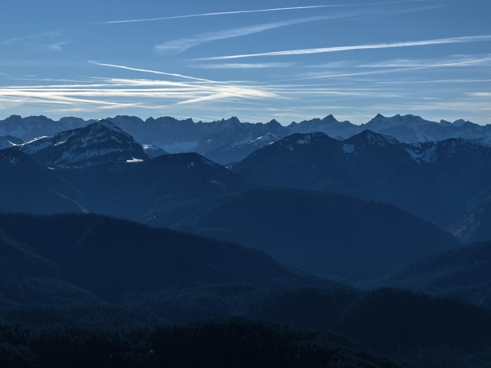 a view of a mountain range with a few clouds in the sky