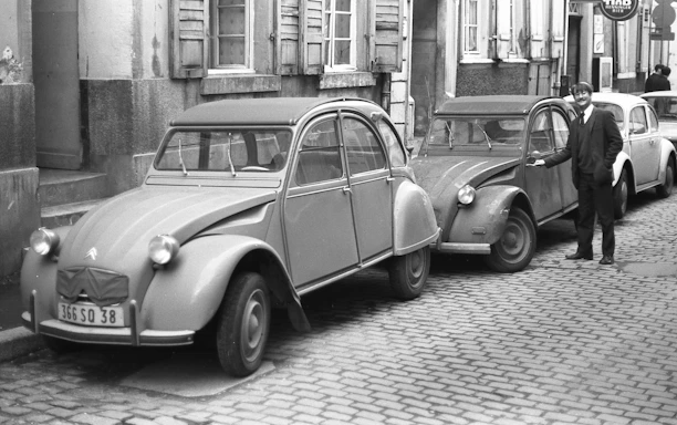 Vintage 2CV cars lined up at a sunny vineyard during the event.