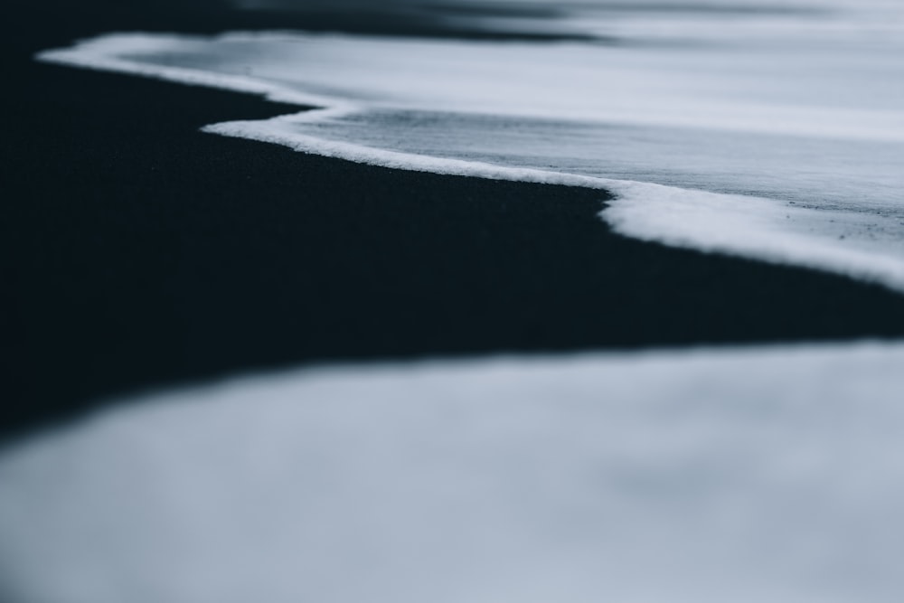 a black and white photo of water and sand