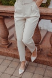 a woman wearing a white suit and heels