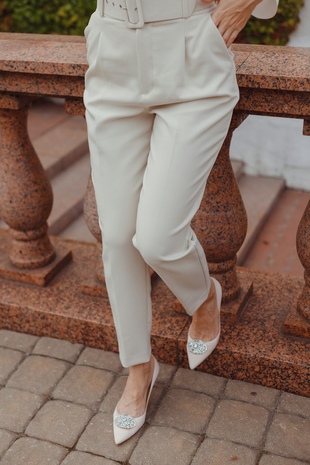 a woman wearing a white suit and heels