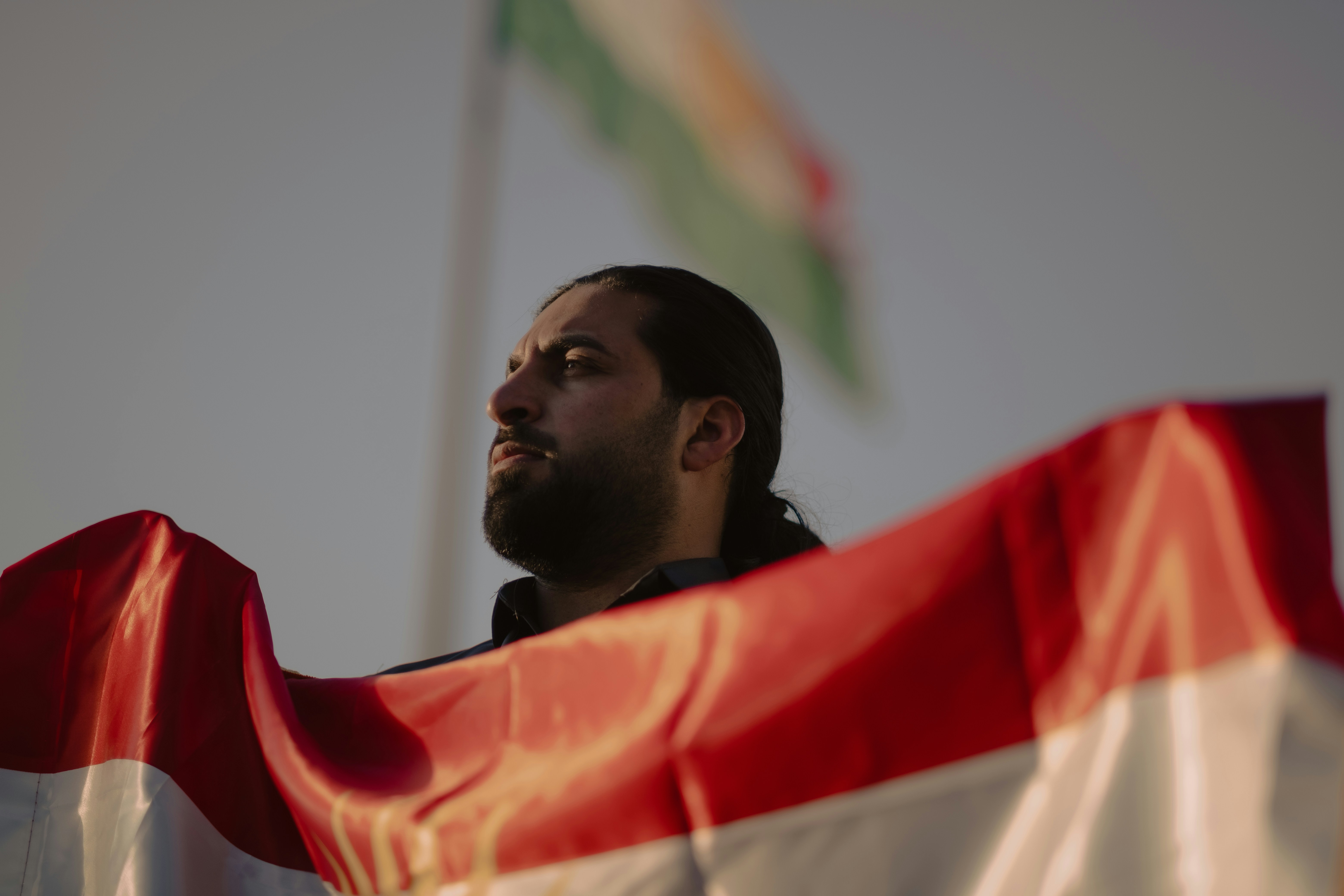 Un hombre con barba sosteniendo una bandera
