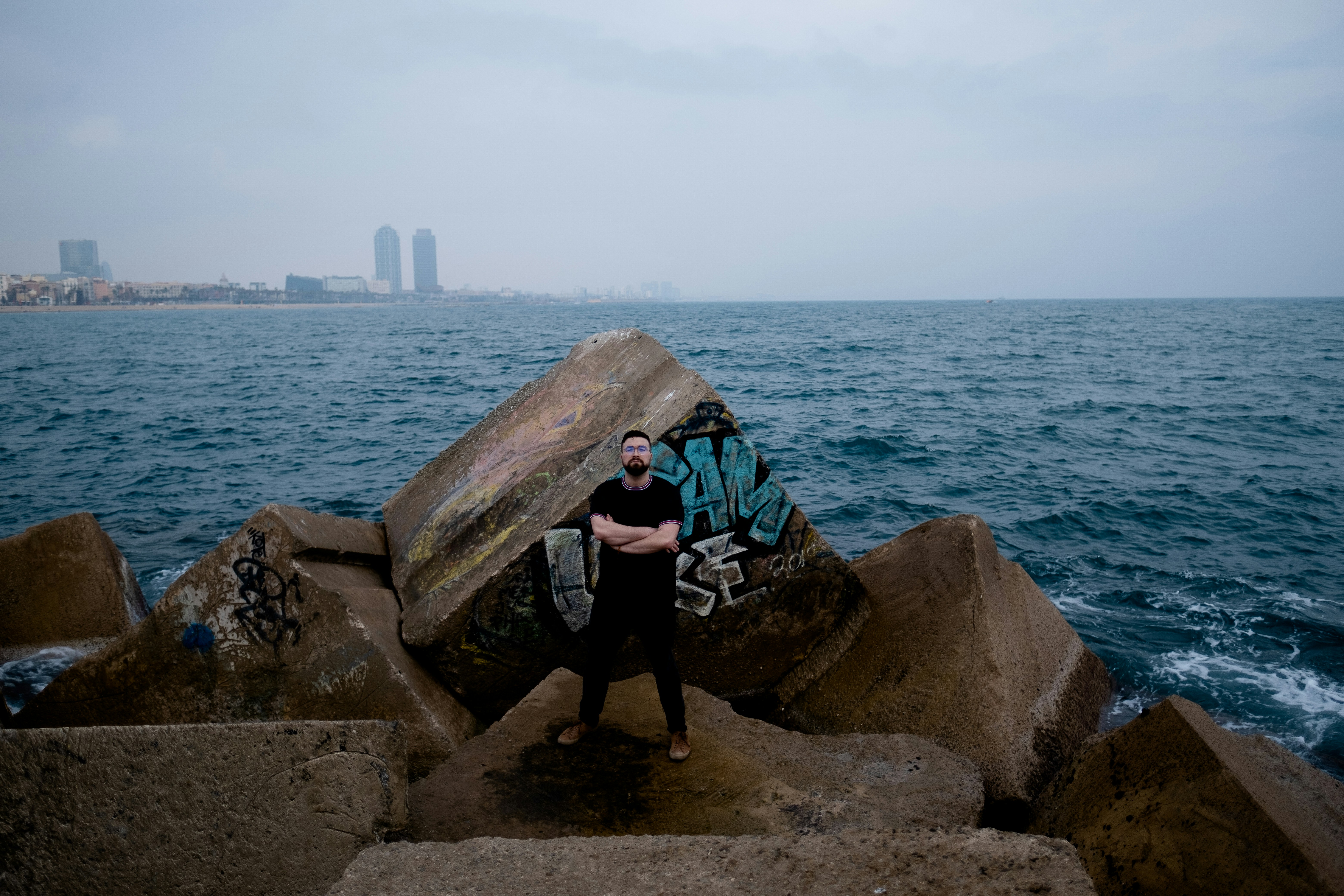 Un homme debout sur un rocher au bord de l’océan