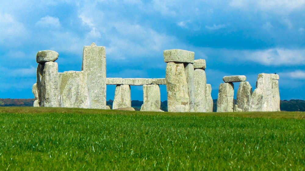 a stonehenge in the middle of a grassy field