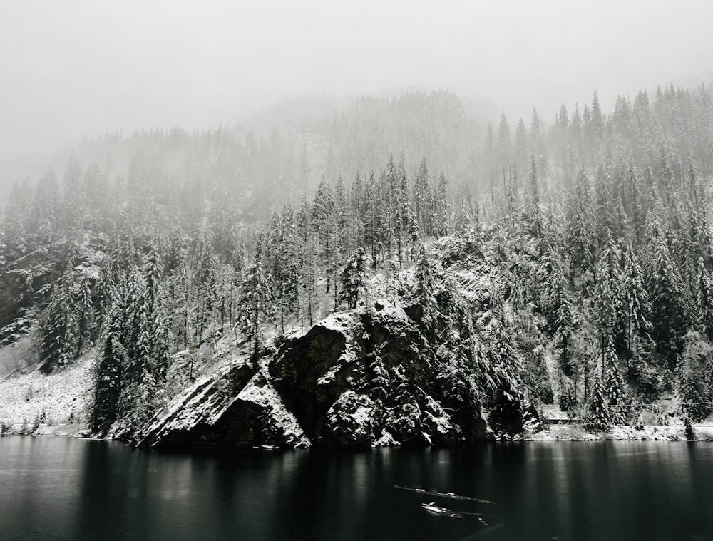 a mountain covered in snow next to a lake