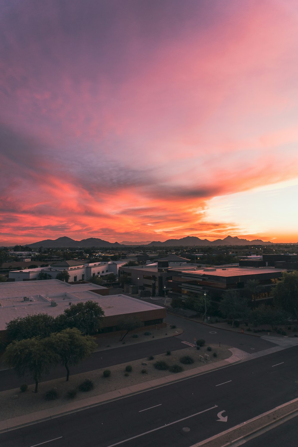 una vista del tramonto di un edificio e un parcheggio