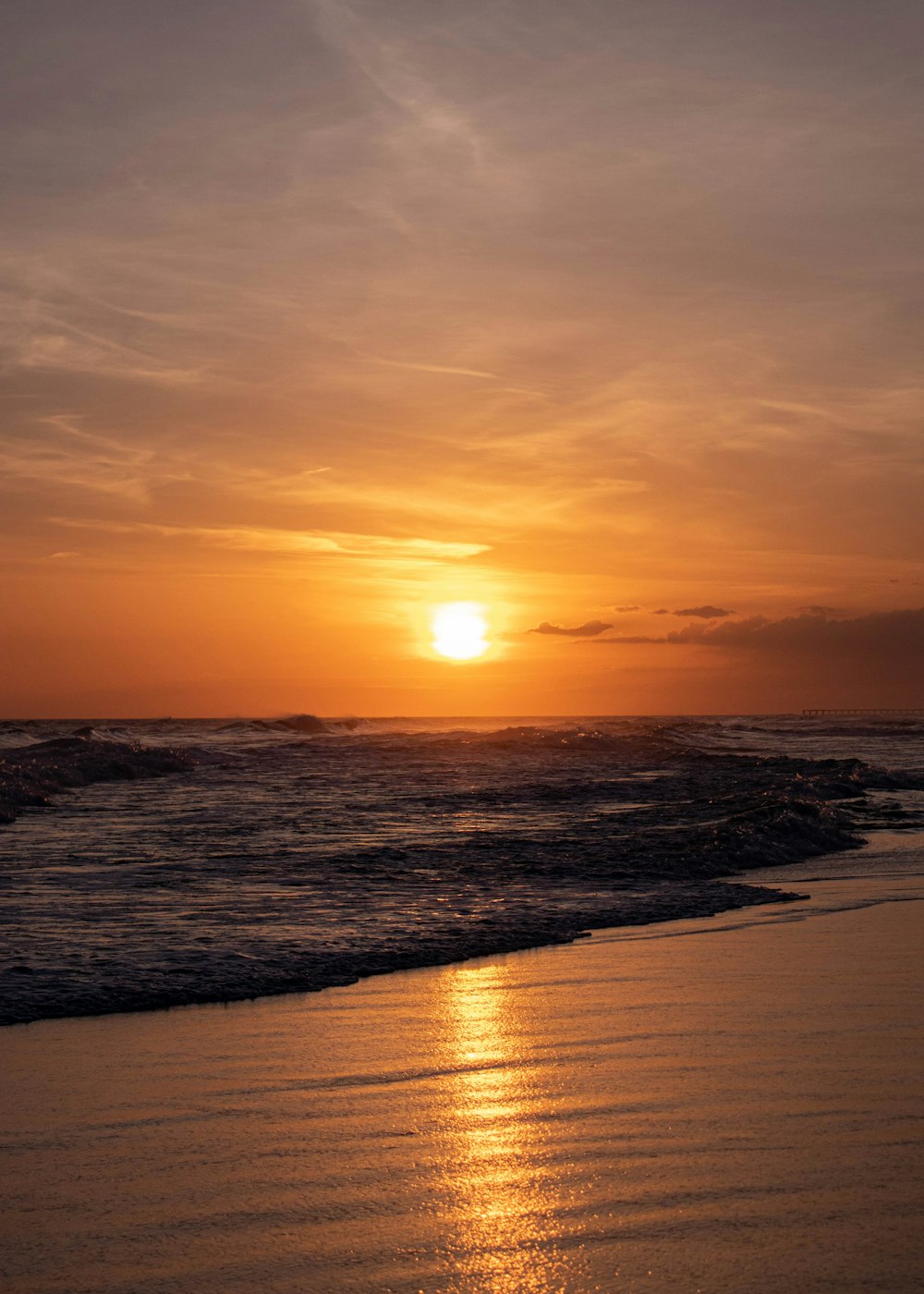 El sol se está poniendo sobre el océano en la playa