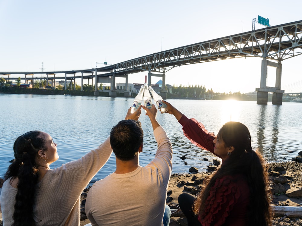 a group of people standing next to a body of water