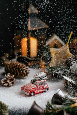 a red toy car sitting on top of a snow covered ground
