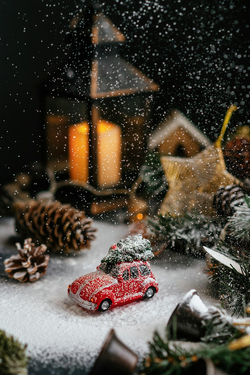 Un coche de juguete rojo sentado encima de un suelo cubierto de nieve
