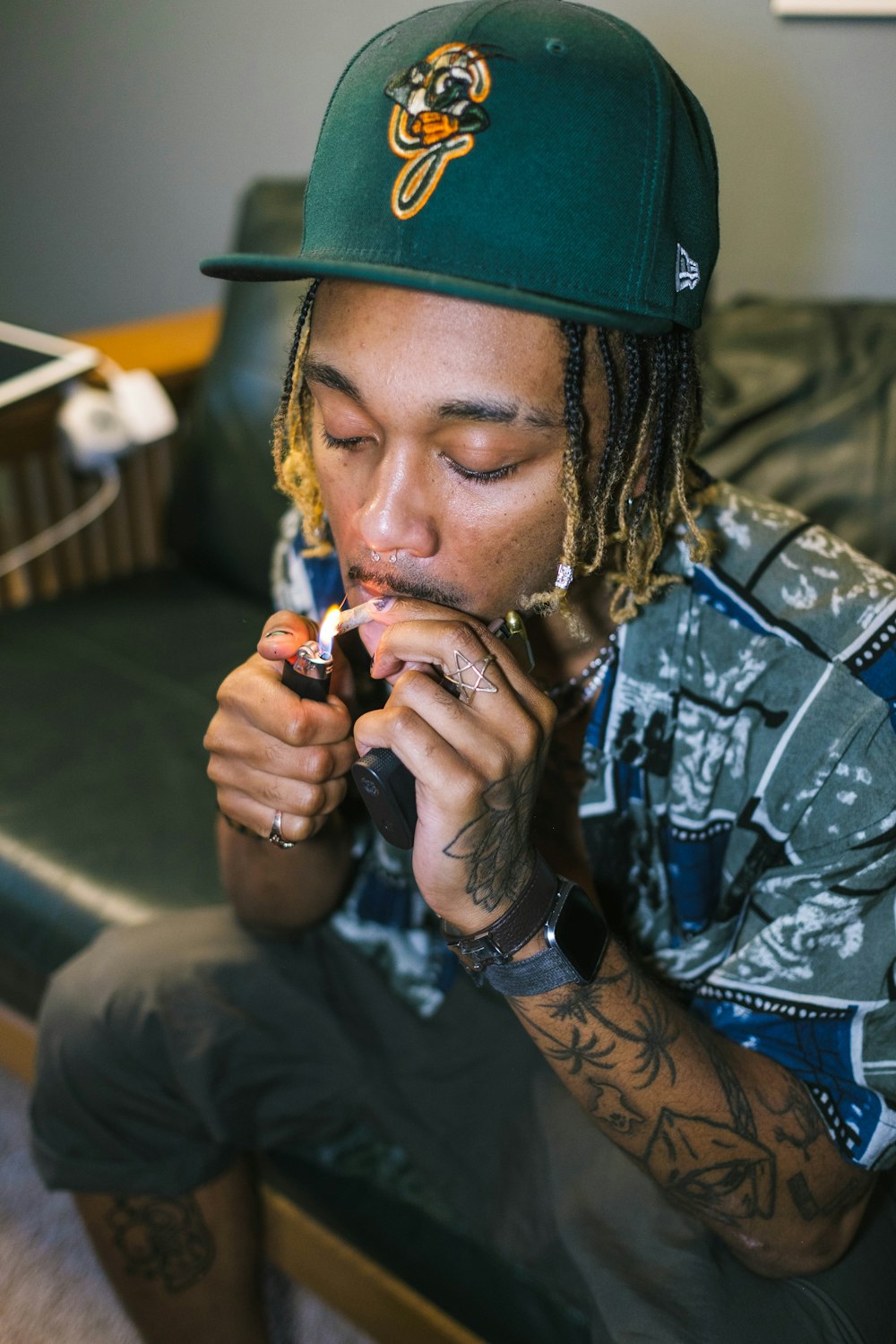 a man sitting on a couch with a cigarette in his mouth