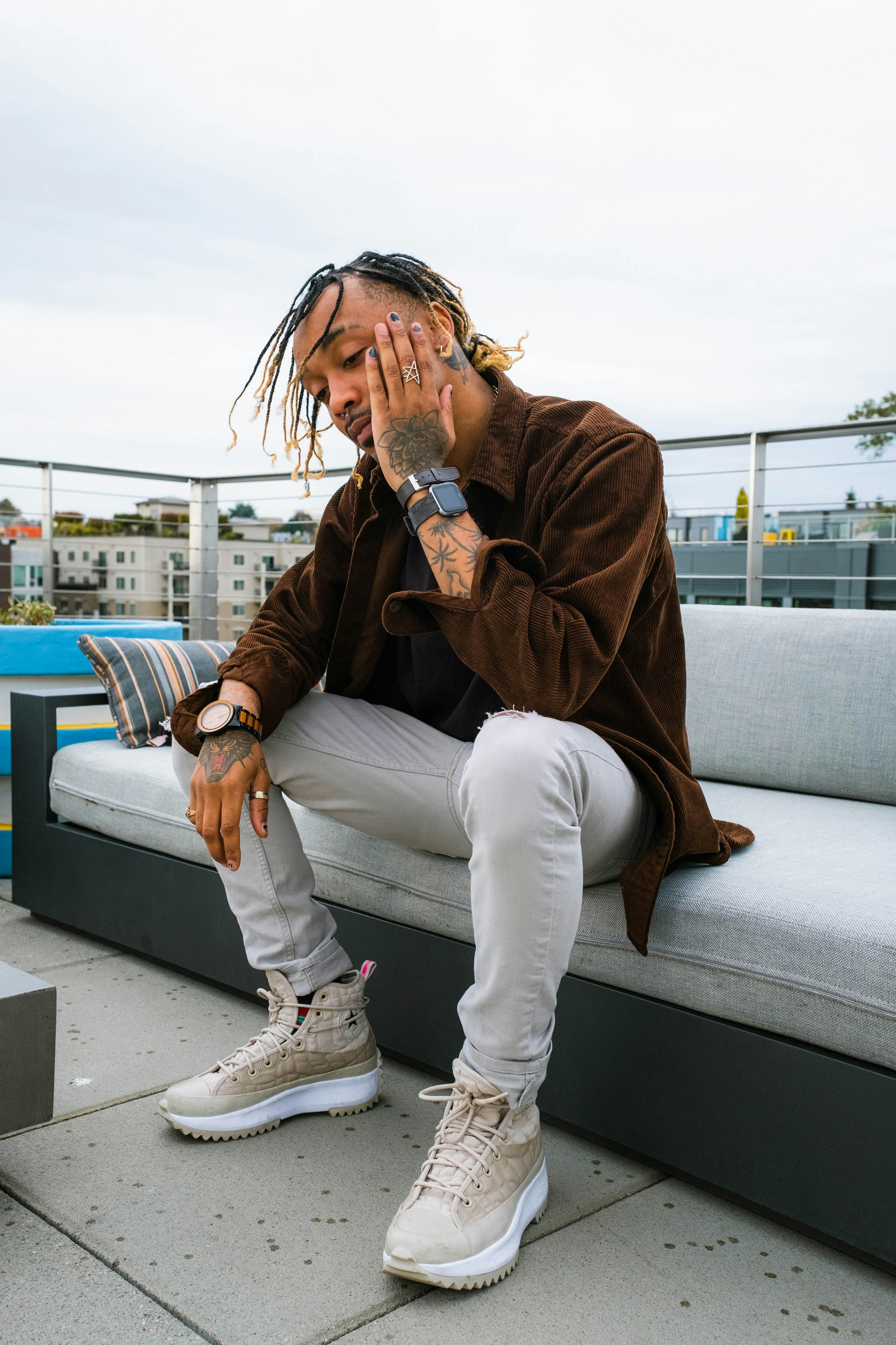 a man with dreadlocks sitting on a bench