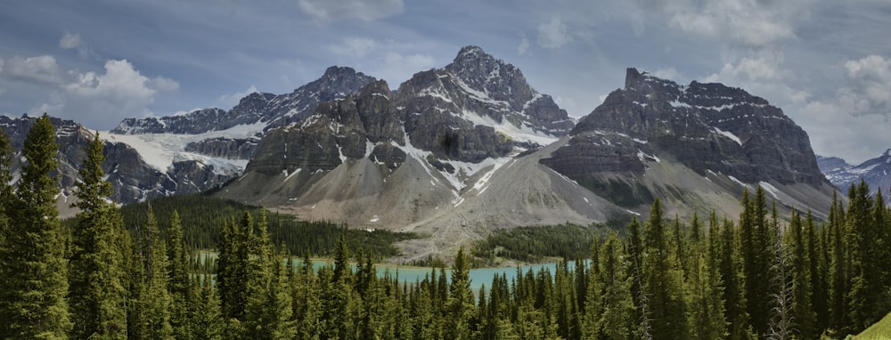 a scenic view of a mountain range with a lake in the foreground